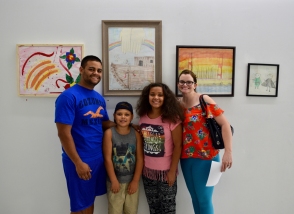 Family stands in front of their new art work purchased at the MNA Exhibition 2017